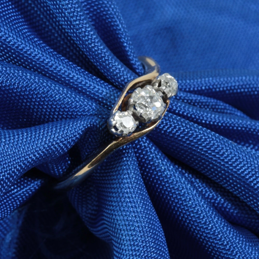 Three stone diamond crossover ring